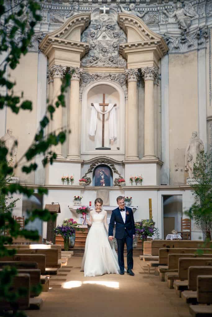 Jaunieji eina bažnyčios praėjimu po vestuvių ceremonijos