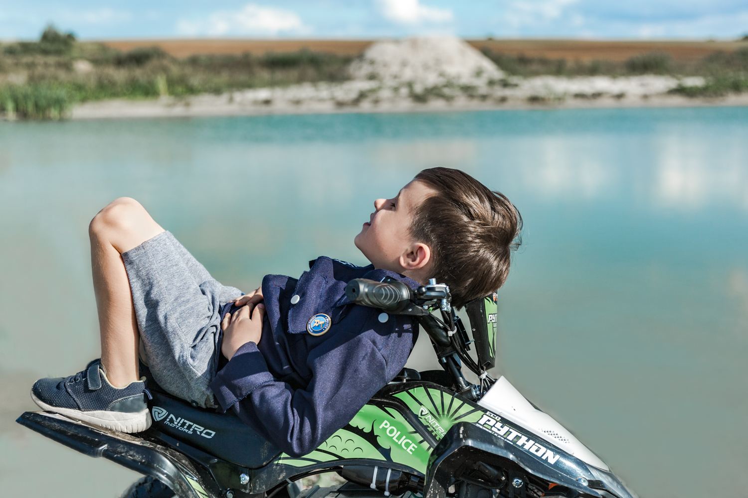 Berniukas guli ant žalio Python keturračio