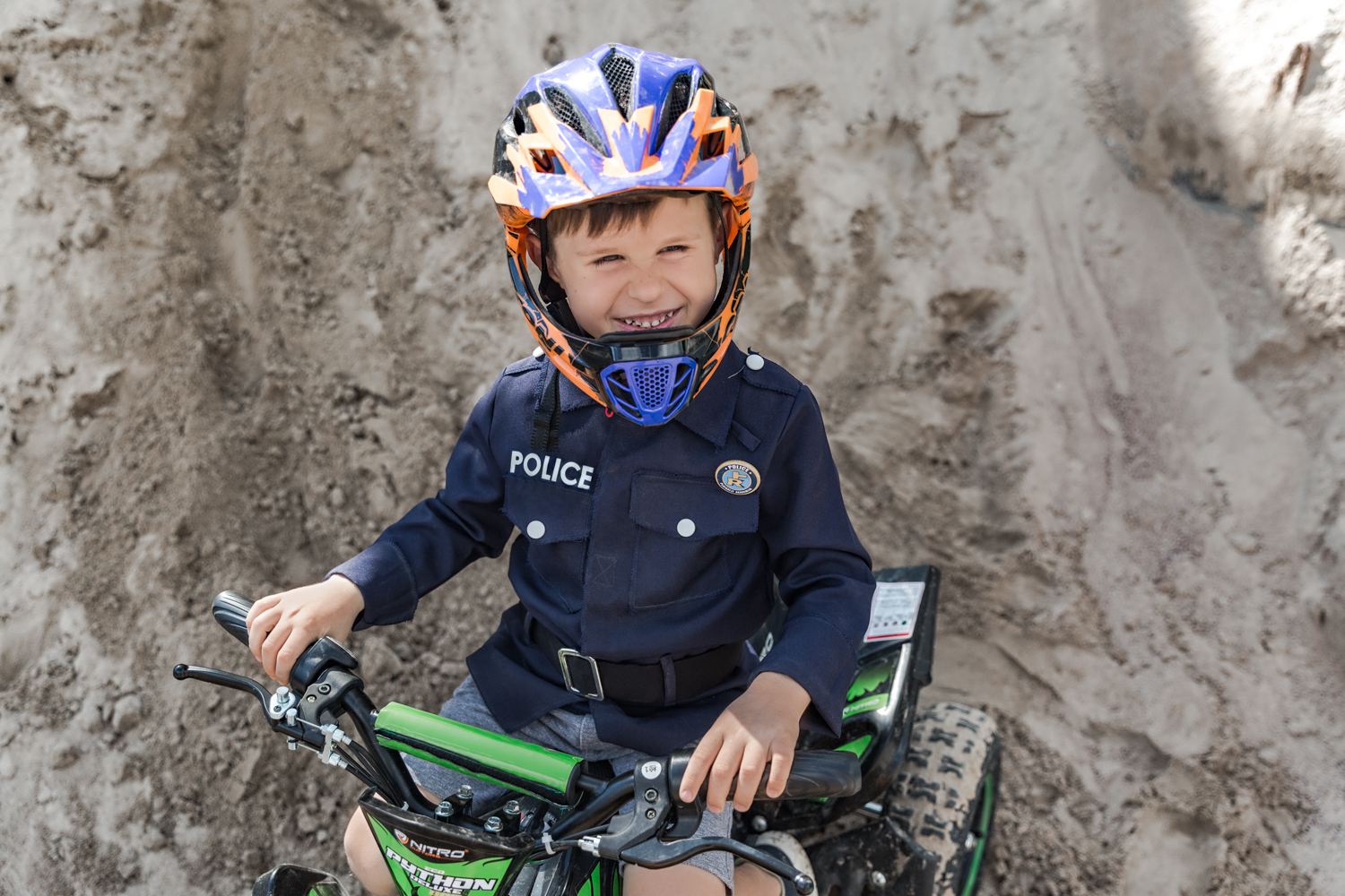vaikas su policininko apranga šypsosi